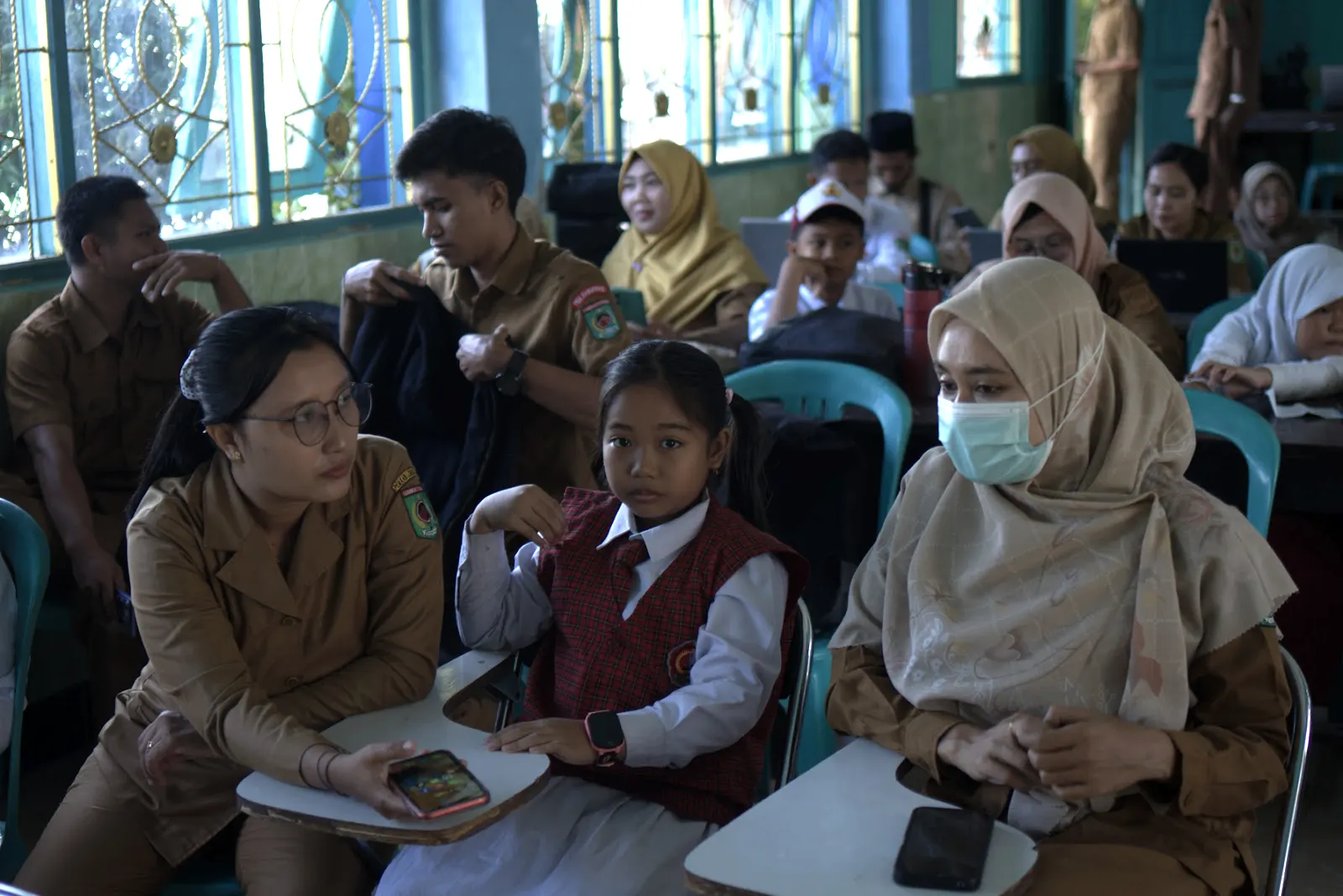 Guru dan siswa duduk berdampingan mengikuti sesi di ruang kelas di Lombok